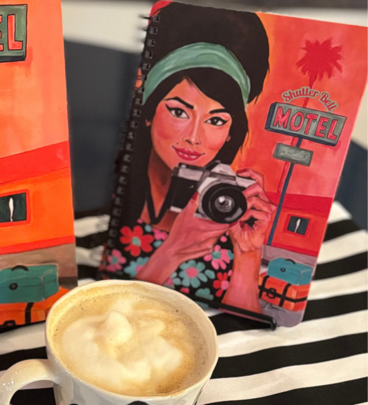 Front cover of the Shutter Bell art notebook featuring a retro-inspired brunette woman holding a camera; vibrant aesthetic journal for women who love photography.
