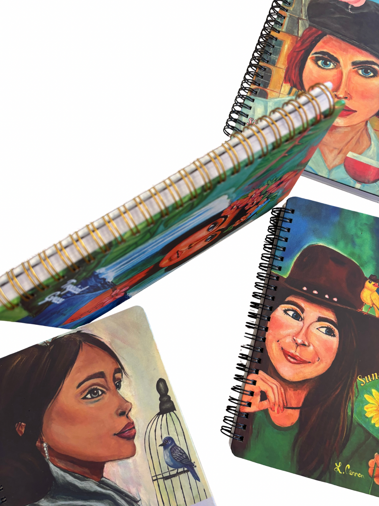 Spine detail shot of the Femmes & Feathers art notebook collection with several front covers visible; colorful feminine illustrated journals displayed together.