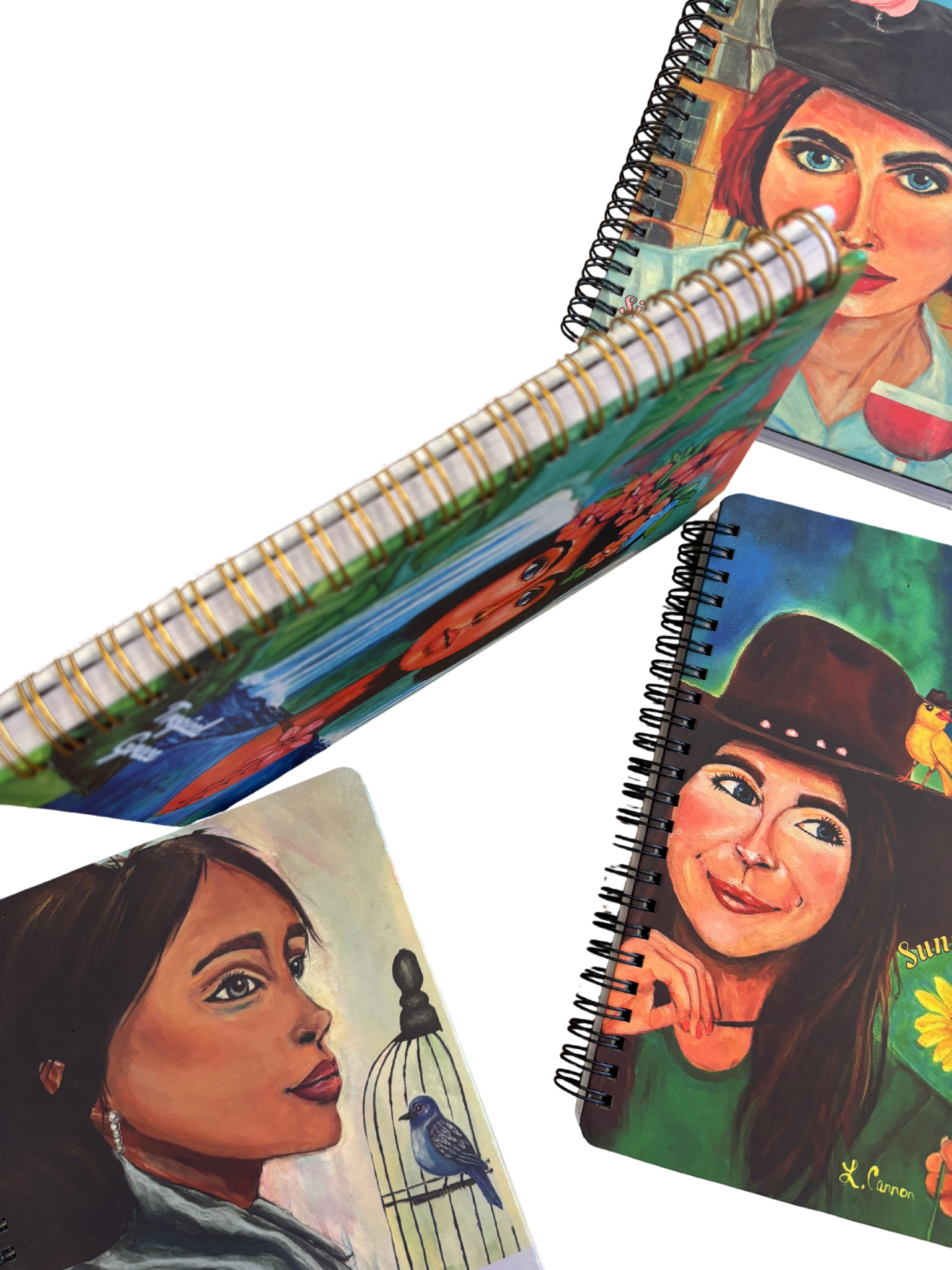 Spine detail shot of the Femmes & Feathers art notebook collection with several front covers visible; colorful feminine illustrated journals displayed together.
