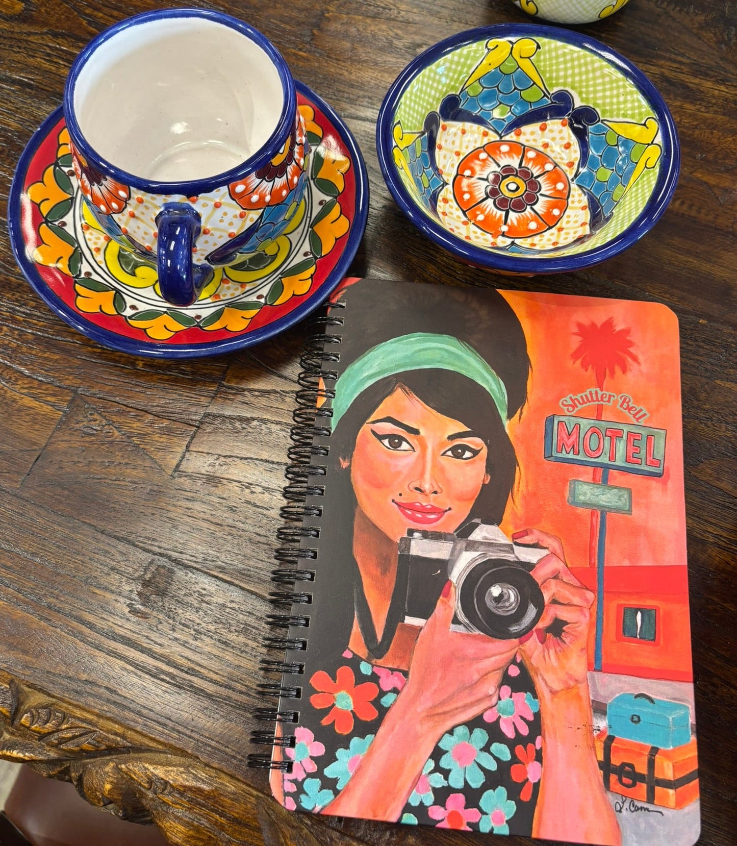 Shutter Bell art notebook featuring a retro camera girl illustration, styled on a table with a colorful coffee cup and bowl; aesthetic product photo for journal lovers.