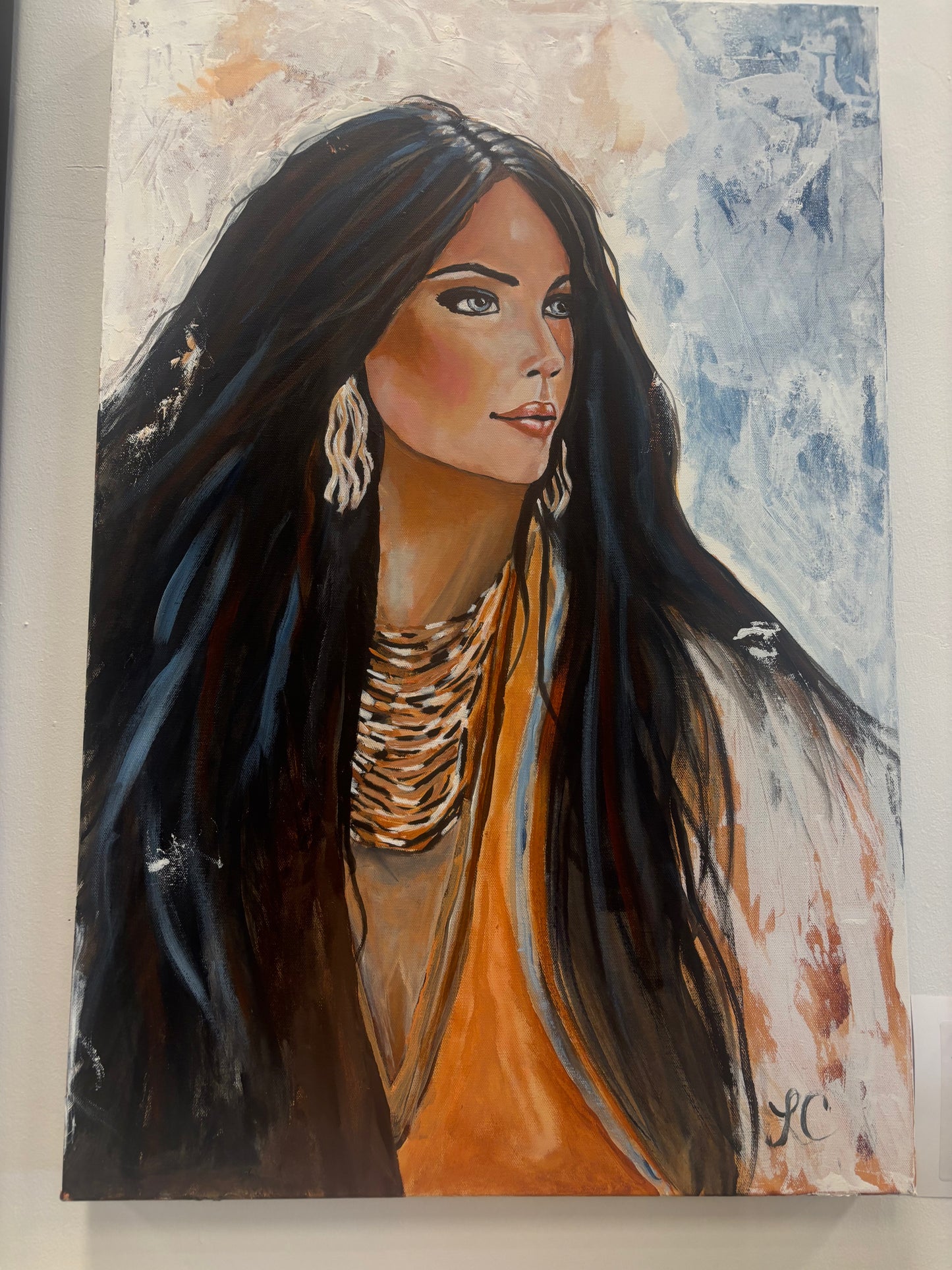 Canvas Print of a woman with long dark hair and an orange top against a textured background