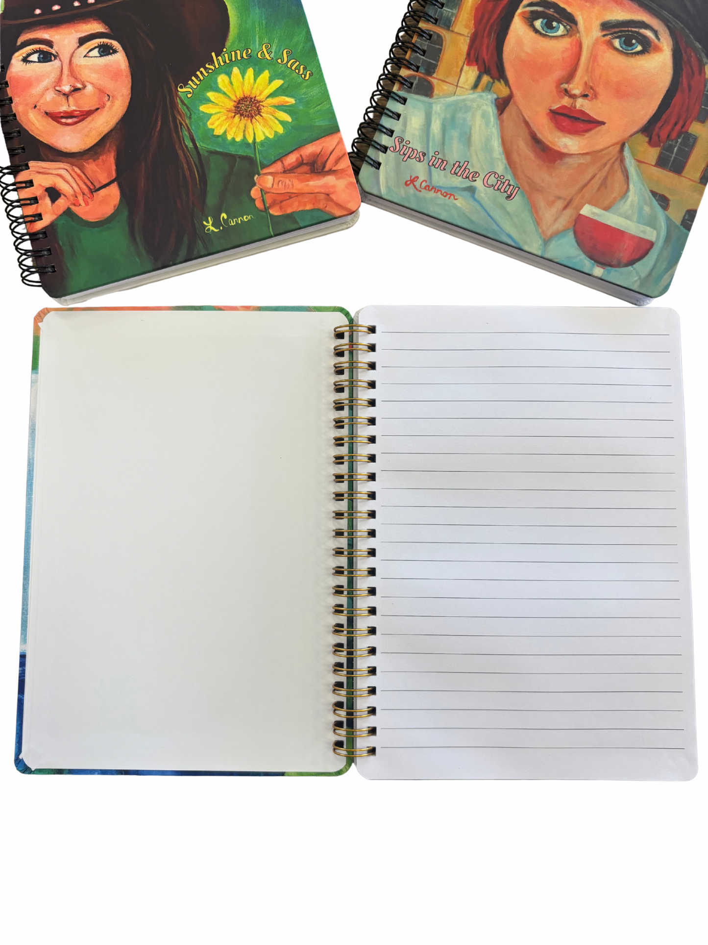 Open lined notebook displayed with the Sips in the City and Sunshine & Sass art notebook covers above it; feminine illustrated journals from the Femmes & Feathers collection shown with interior pages.